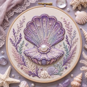 May include: A circular embroidery hoop featuring a central purple seashell with a large white pearl at its centre. The shell is surrounded by embroidered purple and light blue sprigs, small beads, and additional shell motifs on a cream fabric.