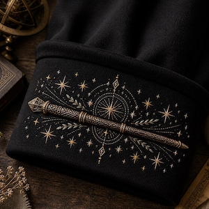 以下が含まれることがあります： 黒いニット帽。金色の刺繍で魔法の杖、星、幾何学模様が描かれています。デザインは折り返されたつばにあります。帽子は暗く柔らかい生地で作られています。