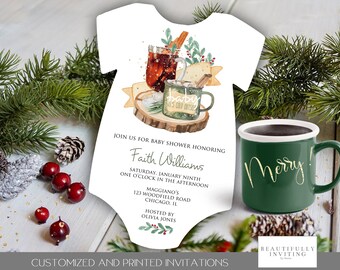 May include: A baby shower invitation in the shape of a onesie, featuring a watercolor illustration of a hot drink and the text "Baby It's Cold Outside." A green mug with "Merry!" in gold lettering is next to the invitation. The invitation includes the baby shower details.