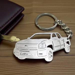 May include: A white ceramic mug with a black handle and the text "But First, Coffee" in a black, bold font. The mug is on a white surface. The mug is approximately 4 inches tall.