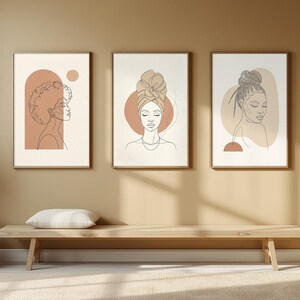Könnte beinhalten: Drei gerahmte Wandbilder mit Strichzeichnungen von Frauen mit verschiedenen Frisuren. Jeder Druck enthält sanfte terrakottafarbene und beige geometrische Formen auf cremefarbenem Hintergrund, angeordnet in einer Reihe.