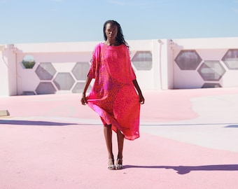 Vestido largo estilo años 60 con estampado abstracto en rosa brillante y morado, estilo caftán vintage con botones y mangas abullonadas.