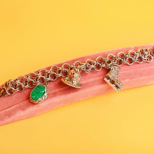Vintage 80s Silver Tone Charm Bell Green Stone Ice Skates Braided Chain Bracelet