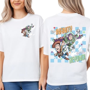 Pode incluir: Camiseta branca com um desenho animado de Woody e Buzz Lightyear. A parte de tr&aacute;s da camisa tem a frase "to INFINITY and BEYOND!" com os mesmos personagens. O design inclui azul, verde, marrom e amarelo.