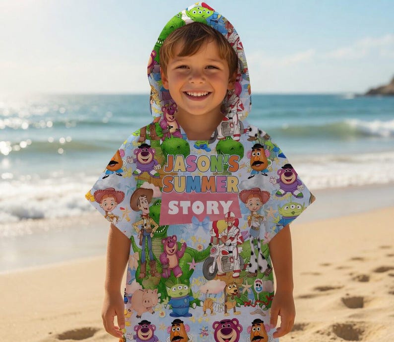 May include: A light blue hooded beach towel featuring characters from the Toy Story movie. The towel has the text "JASON'S SUMMER STORY" in pink and yellow. The hood is green with an alien print.