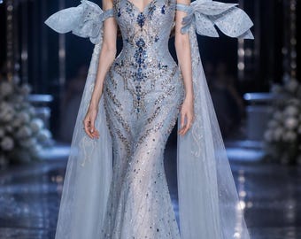 Vestido de noche de sirena azul hielo cristalino con mangas de capa transparente y bordado con cuentas.
