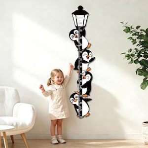 May include: A vertical wall-mounted growth chart featuring a black street lamp at the top with the name Simon printed on it. Four cartoon penguins are positioned along the central measuring scale, which is marked in centimeters from 30 to 160.