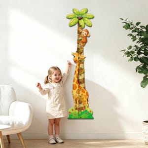 Pode incluir: Uma régua de crescimento vertical para parede com uma girafa e um macaco a subir uma palmeira. O design inclui uma escala numerada em centímetros, folhagem verde na base e o nome Simon impresso nas folhas da palmeira no topo.