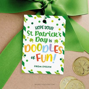 May include: A white gift tag with green, yellow, and red stripes. The tag has a shamrock design and the text "HOPE YOUR St Patrick's Day is DOODLES of FUN! FROM EVELYN".