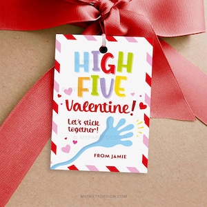 May include: A Valentine's Day gift tag with a red and white striped border and a red ribbon. The tag reads "HIGH FIVE Valentine!" with a blue hand graphic and the text "Let's stick together!" and "FROM JAMIE".