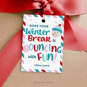 May include: A white gift tag with a red ribbon. The tag has a winter theme with the text "Hope Your Winter Break is Bouncing with Fun!" and a snowman illustration. The tag is from Jamie.