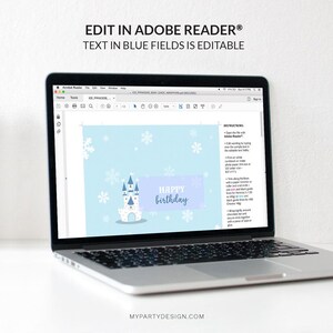 May include: A laptop displays a light blue birthday card design. The card features a castle illustration, snowflakes, and the text "HAPPY birthday" in a purple banner. The screen also shows instructions and the text "EDIT IN ADOBE READER&reg;".