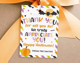 Op de afbeelding: Een Halloween-cadeaulabel met een oranje strik. Het label heeft de tekst "THANK YOU" en "APPRECIATE YOU!" in verschillende kleuren, samen met een pompoen- en vleermuisafbeelding. Het label zegt ook "Happy Halloween!" en "FROM THE SMITHS."