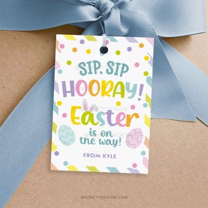 May include: A colorful Easter gift tag with the text "Sip, Sip Hooray! Easter is on the way!" and the name "Kyle". The tag is decorated with colorful eggs, polka dots, and stripes.