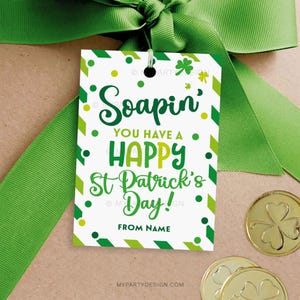 Può includere: Un'etichetta regalo bianca con strisce verdi e gialle e pois. L'etichetta dice "Soapin' You Have A Happy St. Patrick's Day!" con uno spazio per un nome in basso.