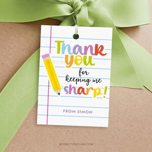 Puede incluir: Una taza de cerámica blanca con un asa negra y el texto "But First, Coffee" en negrita negra. La taza se encuentra sobre un fondo borroso, resaltando su diseño limpio.