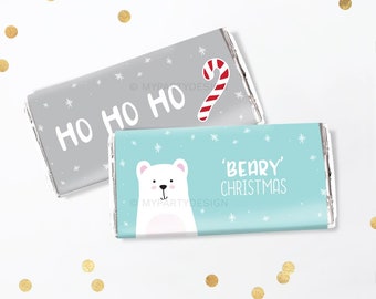 May include: Two wrapped candy bars with Christmas-themed designs. One is gray with "HO HO HO" and a candy cane. The other is light blue with a polar bear graphic and the words "'BEARY' CHRISTMAS". Both have snowflake accents.