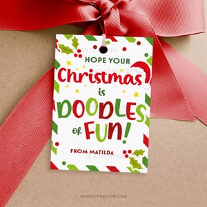 May include: A Christmas gift tag with a red ribbon. The tag has a white background with green and red accents, holly, and the text "Hope Your Christmas is Doodles of Fun!" and "From Matilda."