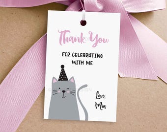 May include: Thank you for celebrating with me. A gray cat wearing a black and white party hat with pink text. Love, Mia.