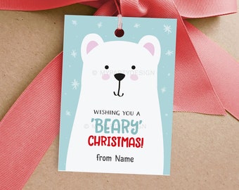 May include: A gift tag with a cartoon polar bear design. The tag has a light blue background with white snowflakes and the text "Wishing you a 'Beary' Christmas!" in red and blue. A pink ribbon and bow are in the background.
