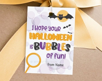 May include: A Halloween-themed gift tag with the text "I hope your Halloween is bubbles of fun!" in orange, purple, and black. The tag features a bat, moon, and bubbles design, with a yellow ribbon tied at the top.