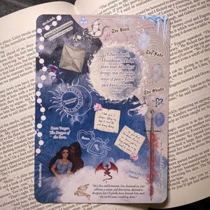 May include: A fantasy art card with a blue and white color scheme. It features illustrations of a dragon, a sword, and a couple, along with text elements like "The Burn" and "Chase death, Moonbeam."