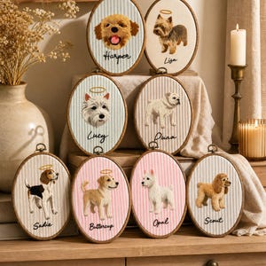 May include: Eight oval embroidery hoops featuring stitched portraits of dogs with names embroidered below each. The dogs include Harper, Lisa, Lucy, Puaa, Sadie, Buttercup, Opal, and Scout. Each dog has a small stitched halo above its head.