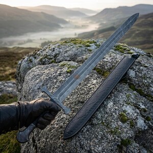 May include: A double-edged sword with a patterned Damascus steel blade and a matching metal hilt, accompanied by a black leather scabbard featuring embossed detailing. The sword exhibits a distinct wavy metal grain texture throughout the blade.