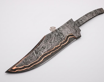 May include: A large, handcrafted knife with a patterned blade and handle. The blade features a dark, textured pattern with copper-colored accents. The handle has a similar pattern. The knife is set against a white background.