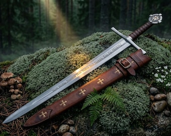 May include: A medieval-style sword with a silver blade and a brown leather-wrapped handle, resting on moss. The sword's blade has an inscription. A brown leather sheath with gold crosses is next to the sword. The background is a forest.