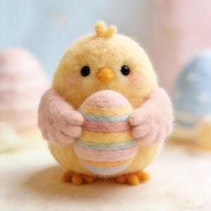 Könnte beinhalten: Eine handgefertigte gelbe Kükenfigur mit rosa Armen, die ein bunt gestreiftes Osterei hält. Das Küken hat schwarze Augen, einen orangefarbenen Schnabel und einen kleinen Kamm. Der Hintergrund ist verschwommen, mit anderen Ostereiern sichtbar.