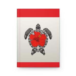 Pode incluir: Um caderno com capa vermelha e fundo creme. O caderno apresenta um desenho de tartaruga preta com uma flor de hibisco vermelha no centro. O desenho da tartaruga tem padrões intrincados.