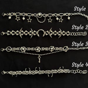 Könnte beinhalten: Vier silberfarbene Choker-Halsketten mit unterschiedlichen Designs werden vor schwarzem Hintergrund gezeigt. Stil 1 hat Sterne und Perlen, Stil 2 hat Stacheln, Stil 3 hat einen Schlüsselanhänger und Stil 4 hat ein Kettengeflecht-Design. Der Text "Style 1", "Style 2", "Style 3" und "Style 4" ist sichtbar.