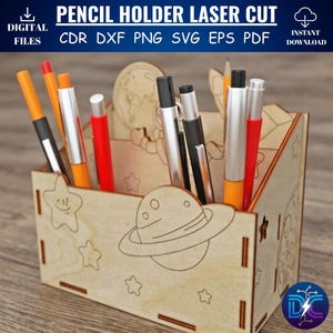 Op de afbeelding: Lasergesneden houten potloodhouder met een ruimtethema. De houder heeft een planeet- en sterontwerp en bevat verschillende pennen en potloden. Tekst op de afbeelding luidt "PENCIL HOLDER LASER CUT" en "DIGITAL FILES".