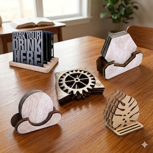 May include: A collection of wooden coasters in various shapes and designs, including a gear, a leaf, and a set with the text "PARK YOUR DRINK HERE". The coasters are displayed on a wooden table.