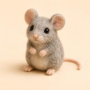 May include: A needle-felted mouse figurine crafted from grey wool with a lighter cream-coloured belly. The mouse features round pink-toned ears, a small pink nose, black bead eyes, and tiny pink paws, standing upright with a long thin tail extending outward.