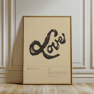 Può includere: Una stampa artistica incorniciata con la parola "Love" in uno stile a pennellate scure. Lo sfondo è di colore beige chiaro. La stampa include del testo in basso, con il nome dell'artista e una definizione di amore.
