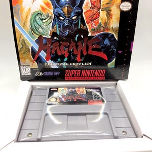 May include: A Super Nintendo Entertainment System video game cartridge titled Hagane: The Final Conflict, featuring a gray plastic casing and a label with the game title and artwork, displayed inside its original black cardboard retail box.