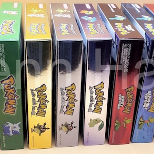 May include: A collection of colorful Pokémon video game boxes, including titles like Ruby, Sapphire, and Emerald. The boxes are arranged in a row, showcasing various game versions with their unique artwork and logos.