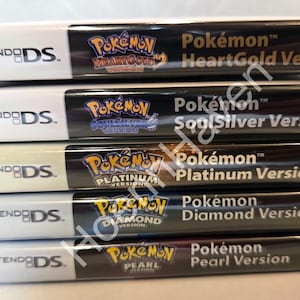 May include: Stacked Nintendo DS game cases featuring Pokémon titles: HeartGold, SoulSilver, Platinum, Diamond, and Pearl versions. Each case has a black spine with the game title in gold lettering and the Nintendo DS logo.