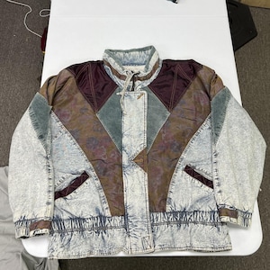 May include: A multi-textured jacket featuring acid-wash denim panels, dark maroon satin sections, and muted green corduroy accents. The jacket has a high collar, a front zipper closure, two side pockets, and an elasticized waistband and cuffs.