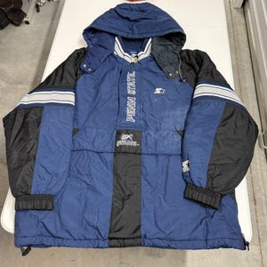 May include: A blue and black Penn State hooded jacket with the text "PENN STATE" vertically down the front. The jacket has a Starter logo and white and gray stripes on the sleeves. The jacket has a zipper and a hood.
