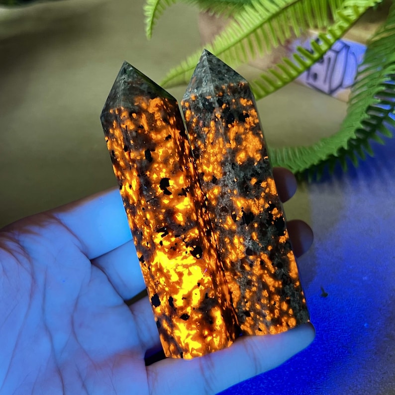 Puede incluir: Dos cristales rectangulares verticales con un patr&oacute;n moteado negro y naranja. Los cristales est&aacute;n iluminados desde dentro, creando un efecto brillante. Los cristales se sostienen en una mano.