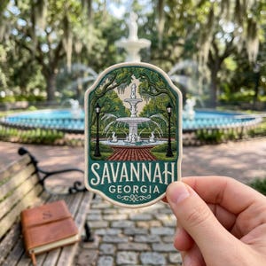 May include: A decorative patch featuring an embroidered illustration of a white tiered fountain surrounded by green trees and two black lampposts. The text SAVANNAH GEORGIA is printed in white capital letters at the bottom of the patch.