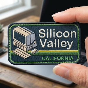 May include: A rectangular embroidered patch with a dark blue background and a green border. It features a beige vintage computer and keyboard graphic, with the white embroidered text Silicon Valley and the green text CALIFORNIA below it.