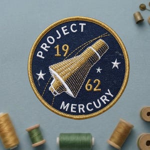 May include: A set of three ceramic mugs with a speckled, matte finish. The mugs are in shades of cream, light gray, and dark gray. Each mug has a simple, minimalist design and a rounded handle.