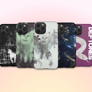 May include: A collection of five phone cases with unique designs. The cases feature images of an owl, a snake, and other graphics, with the band name "Deftones" printed on some. The cases are in various colors, including black, white, and purple.