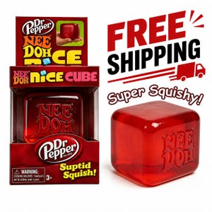 May include: A red Nee Doh Nice Cube stress ball in its packaging, with the Dr. Pepper logo. The cube is translucent and has the Nee Doh logo embossed on it. The packaging includes the text "Suptid Squish!" and a choking hazard warning.