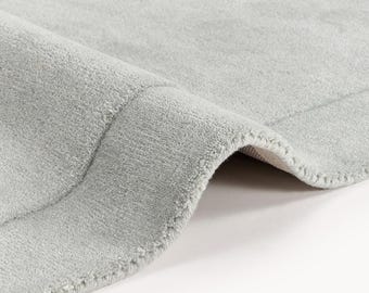 Tappeto in lana grigio chiaro irregolare, trapuntato a mano, stile scandinavo moderno.
