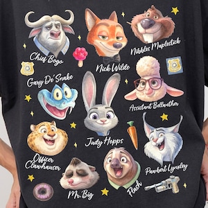 K&ouml;nnte beinhalten: Schwarzes Grafik-T-Shirt mit Zeichentrickfiguren aus Zootopia, darunter Chief Bogo, Nick Wilde und Judy Hopps. Das Shirt hat einen Rundhalsausschnitt und kurze &Auml;rmel. Das Wort "Black" befindet sich in einem schwarzen Kreis oben links.